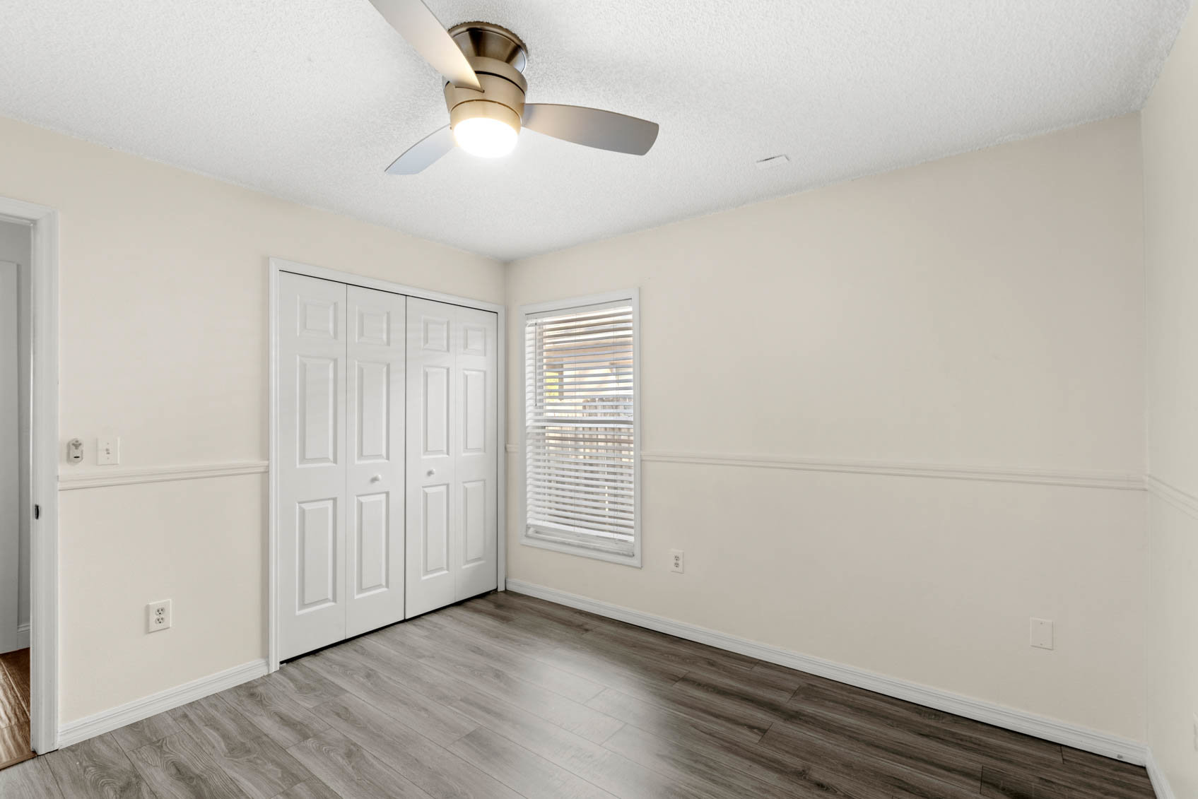 bedroom with grey wooden floors and yellow walls